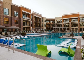 The outdoor pool at an apartment home surrounded by chairs
